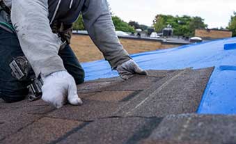 Roof inspection expert thoroughly examining residential roof for damage and wear